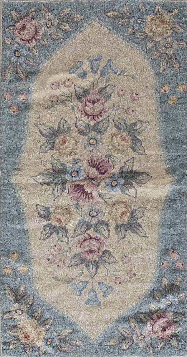 Soft blue and cream narrow rug with an elaborate floral design featuring pink and blue blossoms.