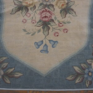 Floral loop pile rug with a cream field, pink roses, blue bellflowers, and a dusty blue border.