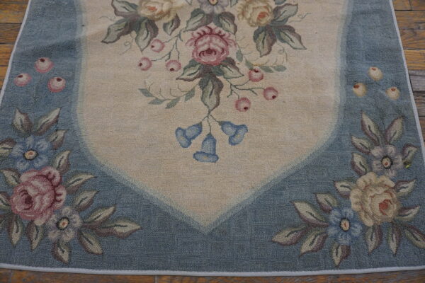 Floral loop pile rug with a cream field, pink roses, blue bellflowers, and a dusty blue border.
