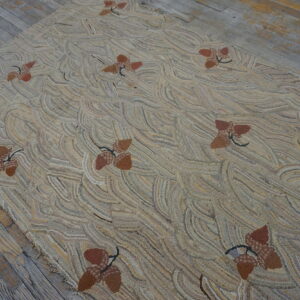 Highly textured tan rug featuring a repeating pattern of brown acorn clusters on gray distressed wood.