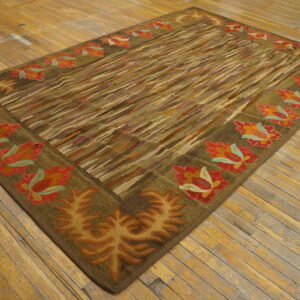 Earth-toned rug with a diagonally striped field and a border featuring large red-orange and gold floral motifs.