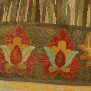 High-pile, earth-toned rug displays abstract forest and large autumnal floral patterns over yellow wood flooring.