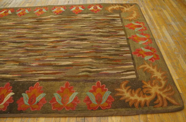 Textured rug featuring a striated center field and a thick olive border with stylized red and orange flowers on wood flooring.