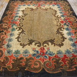 Dark brown, red, and blue ornate rug with sculpted pile lying on light distressed wood flooring.