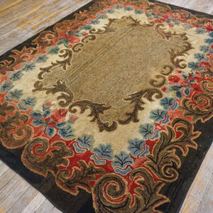 Ornate traditional rug featuring gold, dark brown, red, and blue floral motifs on distressed wood flooring.