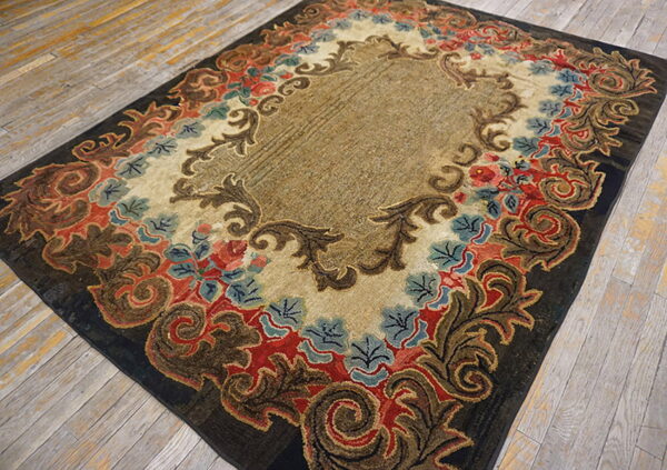 Ornate traditional rug featuring gold, dark brown, red, and blue floral motifs on distressed wood flooring.