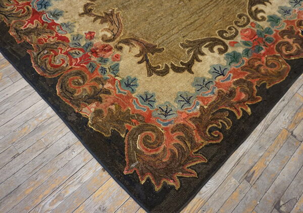 Textured rug corner with brown, red, and blue scrollwork borders resting on light plank flooring.