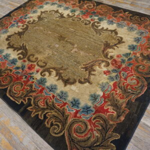 Distressed floral rug featuring an ornate border in red, brown, and blue on weathered wood flooring.