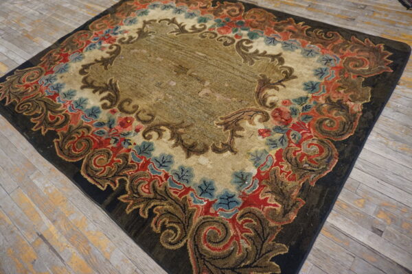 Distressed floral rug featuring an ornate border in red, brown, and blue on weathered wood flooring.