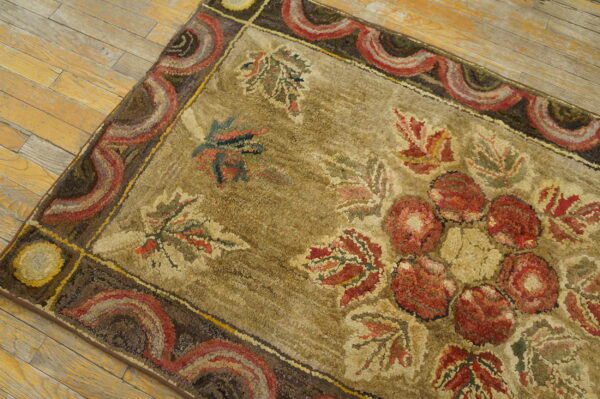 Chunky textured rug displaying large red florals and leaves on a khaki ground with a scalloped border.