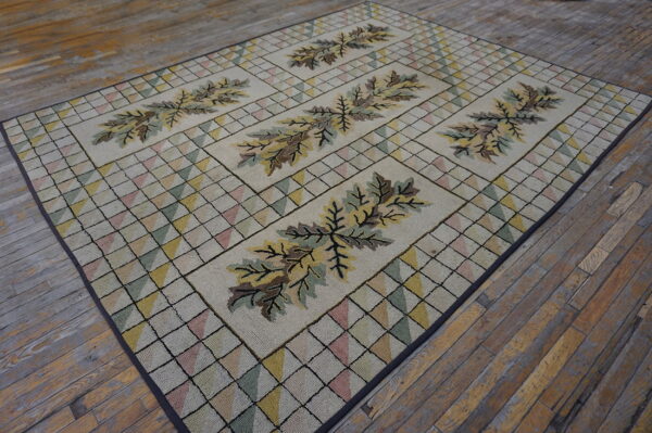 Muted multi-colored hooked rug featuring stylized brown and olive leaf panels on distressed wooden floorboards.
