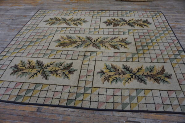 Textured cream rug with leaf motifs and a multicolored triangular grid pattern on distressed wood flooring.