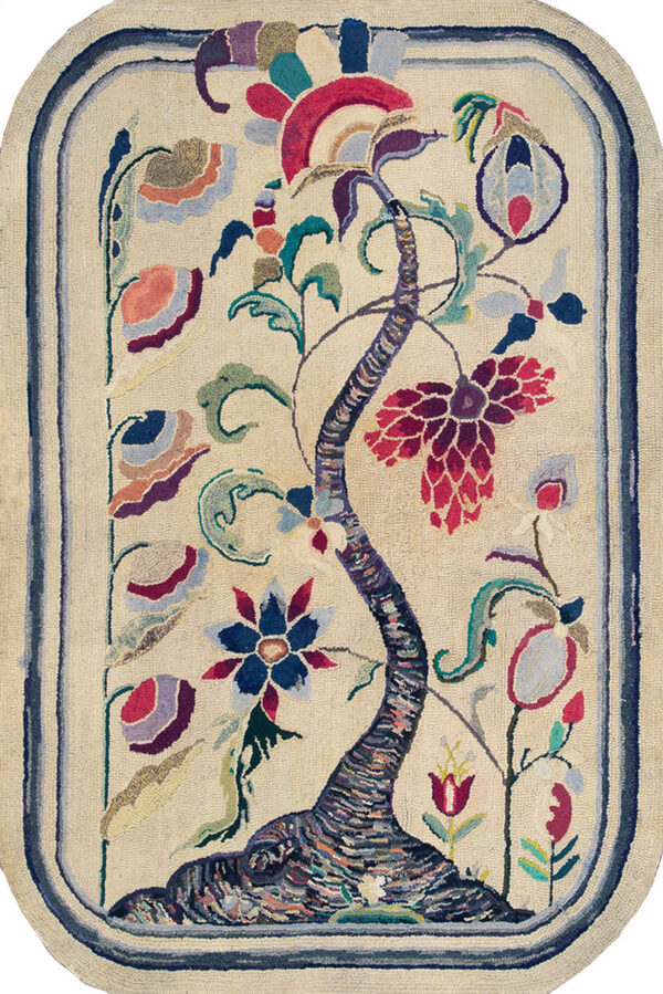 Oblong hooked rug featuring a colorful tree of life motif on a cream field over weathered wood planks.