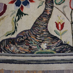 Textured hooked rug featuring a multicolored abstract tree trunk and vibrant red and blue floral patterns.