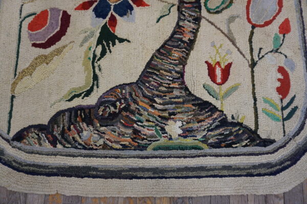 Textured hooked rug featuring a multicolored abstract tree trunk and vibrant red and blue floral patterns.