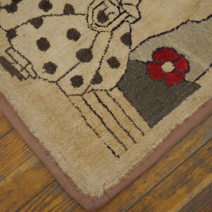 Textured rug with beige, brown, red, and green abstract patterns rests on diagonal distressed wood flooring.