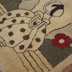 Tan shaggy rug with brown spotted figures, red flower, purple, and green accents displayed on wood flooring.