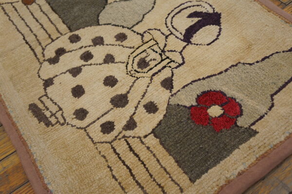 Tan shaggy rug with brown spotted figures, red flower, purple, and green accents displayed on wood flooring.