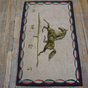 A looped beige rug featuring a central brown and olive horse and compass design on rustic wood plank flooring.
