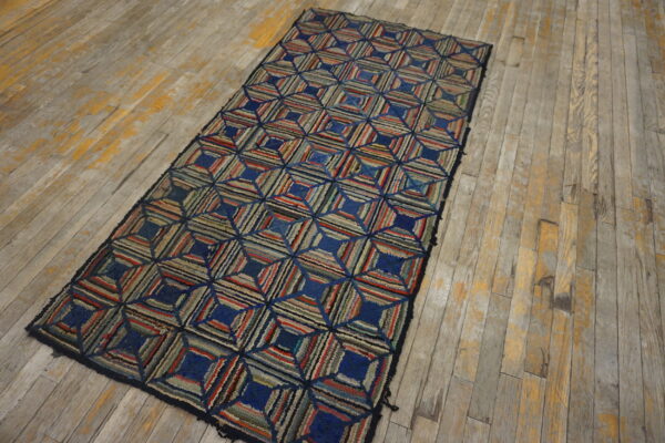 A multicolored rag runner with geometric square pattern sits on distressed wood planks.
