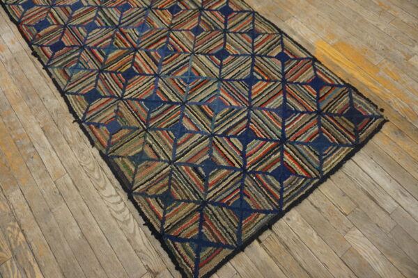 Textured runner rug featuring a multicolored striped diamond pattern and dark blue accents on distressed wood.