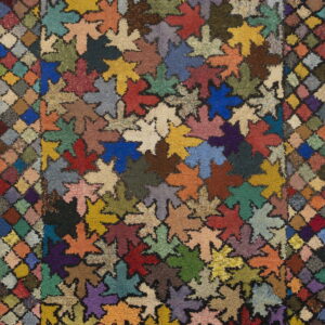 Textured rug displaying multicolored, high-pile leaf shapes surrounded by a variegated diamond border.