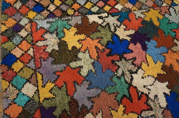 Textured, high-pile rug with variegated colors arranged in large leaf shapes and small diamond patches.