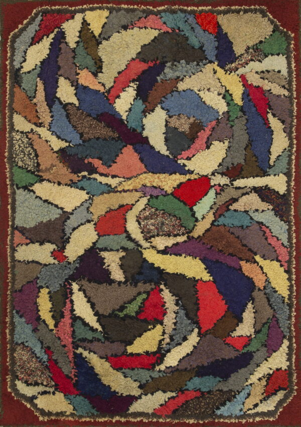 Abstract rug featuring irregular, multi-hued shaggy patches arranged in a dense, swirling design and a dark red border.