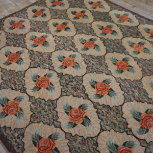 High-texture rug featuring repeating beige scalloped medallions with coral roses on a dark, multicolored ground.