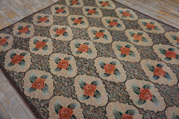 High-texture rug featuring repeating beige scalloped medallions with coral roses on a dark, multicolored ground.