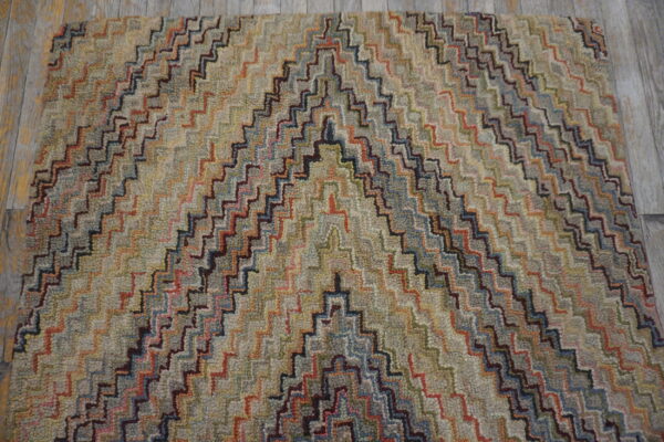 Multicolored chevron rug with a thick, nubbly texture rests on light gray wood flooring.