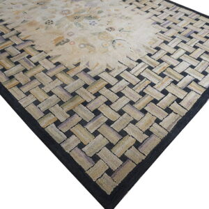 Pale rug featuring a subtle floral center surrounded by a textured border of interwoven light and dark strips.