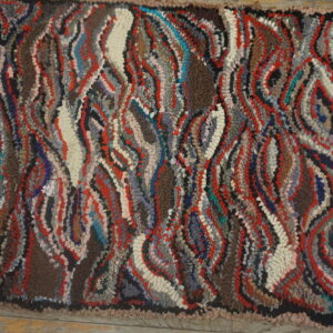 High-pile rug with a textured surface, featuring abstract wavy patterns in red, brown, gray, and cream.