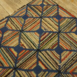 Textured blue and multicolored striped geometric rug detail lying on rustic wooden plank flooring.