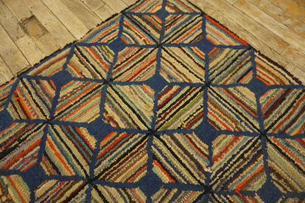 Textured blue and multicolored striped geometric rug detail lying on rustic wooden plank flooring.