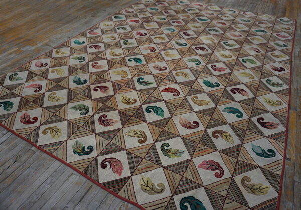 Cream and beige diamond rug with colorful botanical and striped patterns on worn wood flooring.