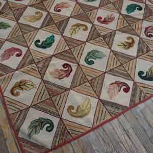 Textured rug with leaf motifs inside cream diamonds and multicolored striped triangles on distressed wood floor.