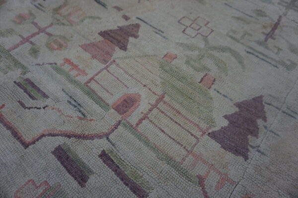 Detail of a rug with a knobby texture and abstract design in beige, purple, pink, and muted green.
