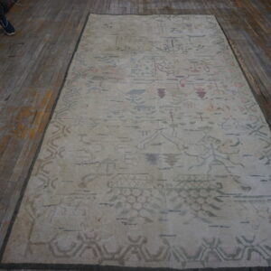 Cream rug with faded abstract patterns in pastel pink, green, and blue, set on rustic wood planks.