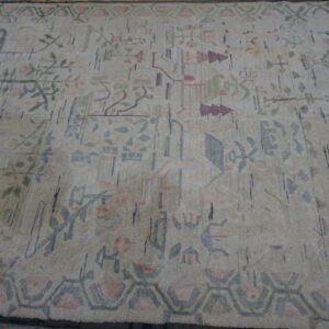 Cream rug with a sparse abstract pattern of faded pink, blue, and green geometric and folk motifs.
