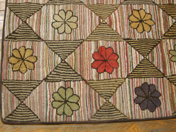 Textured rug featuring a geometric grid of hourglass shapes separating multi-colored floral medallions on striped backgrounds.