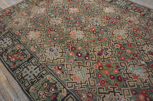 Textured rug displaying dense red and pink florals woven between interlocking brown geometric shapes on wood floors.