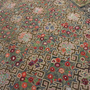 Textural rug with a taupe geometric grid pattern interwoven with bright red and pink floral motifs.