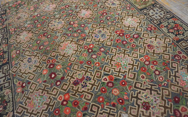Textural rug with a taupe geometric grid pattern interwoven with bright red and pink floral motifs.