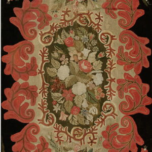 Textured rug featuring coral scrolling leaves and a colorful floral medallion on a dark background.