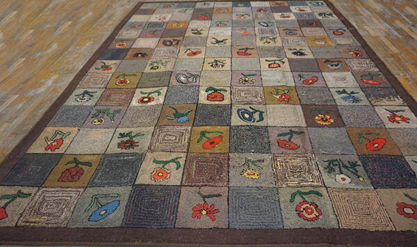 Checkerboard rug with folk flowers and concentric squares in muted grays and browns on wood planks.