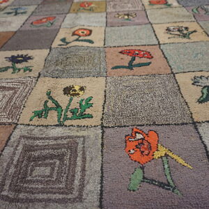 A textured rug features a patchwork grid of squares containing colorful flowers and geometric designs.