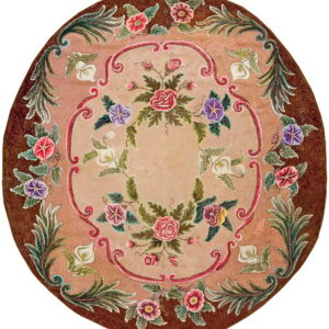 Round dusty rose rug with a dark brown border and ornate multicolored floral and scrolling ribbon designs.
