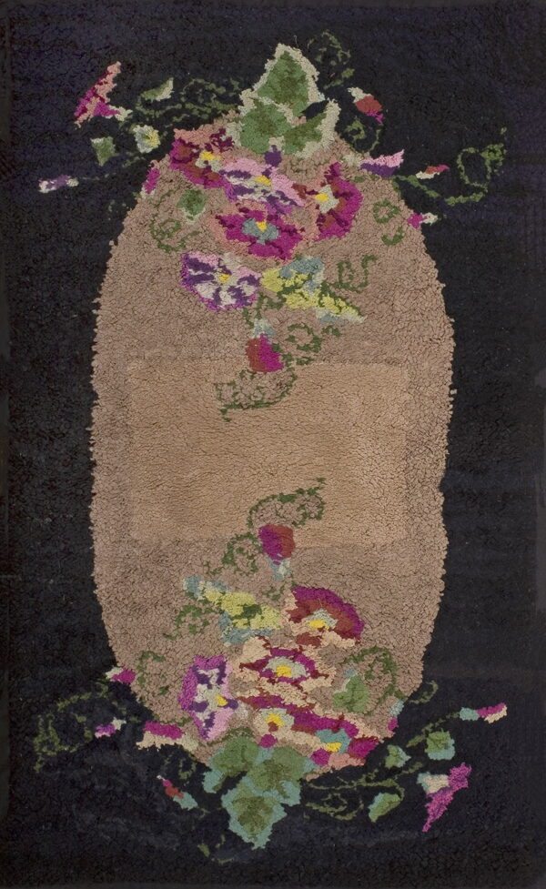 High pile, dark rug featuring a central tan oval medallion with chunky pink, purple, and green floral clusters.
