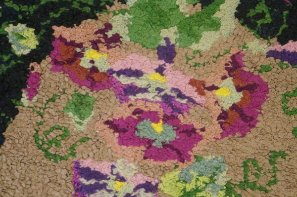 Multicolored high-pile rug detail showing irregular texture blocks of tan, green, purple, magenta, and bright yellow.